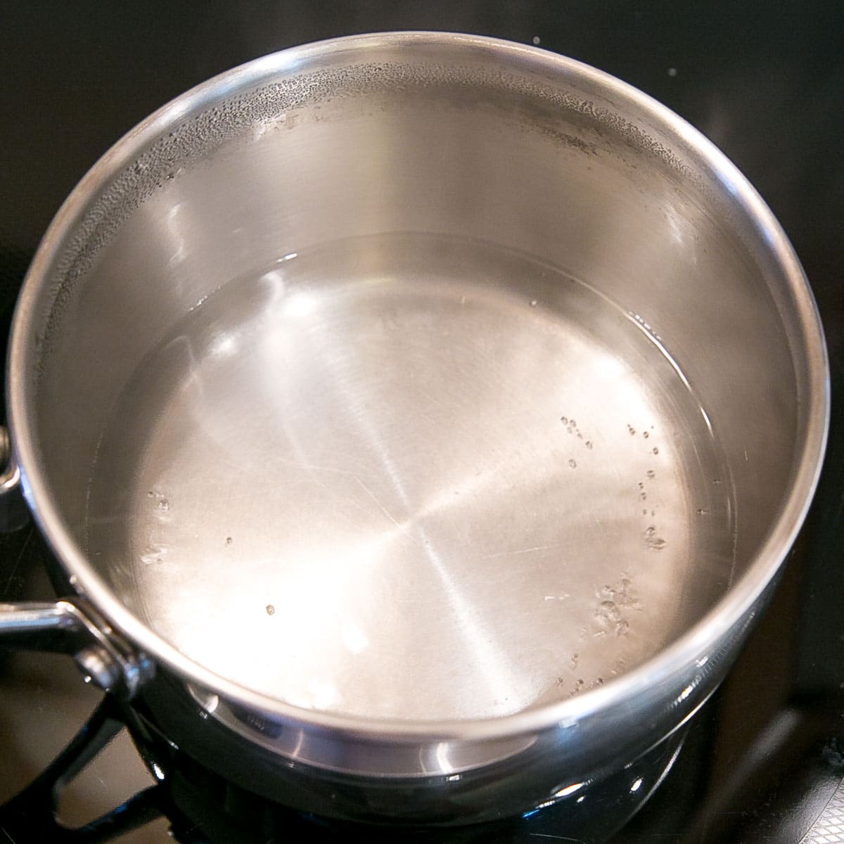 This old-fashioned 7 minute frosting recipe is light, delicious, and easy to make. A pure white frosting that's perfect for a variety of delicious desserts. | livforcake.com A pot with simmering water on the stove.