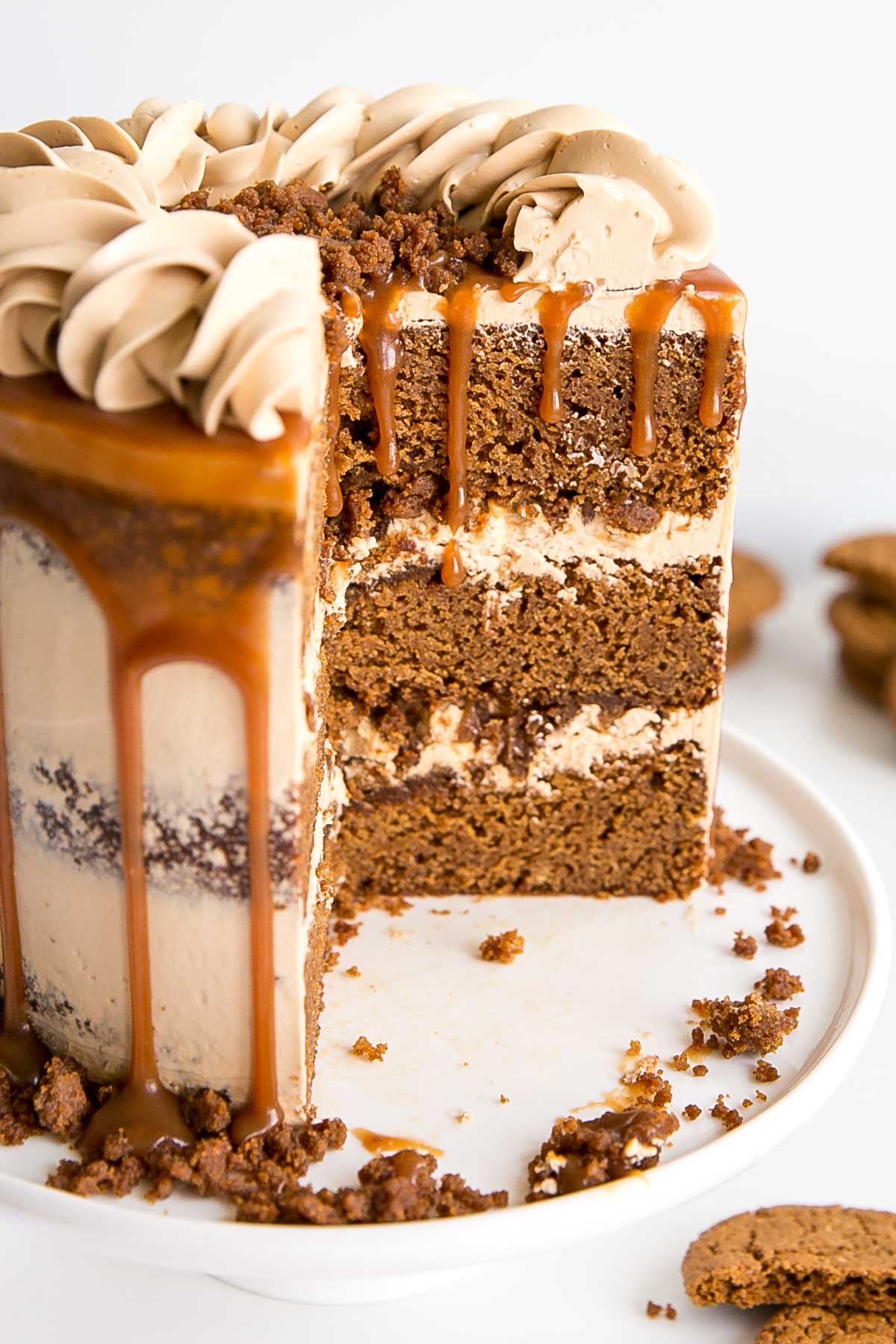 The classic Gingerbread Cake gets a delicious makeover! Gingerbread cake layers and caramel buttercream paired with gingersnap streusel and homemade caramel. | livforcake.com Cross section showing gingerbread cake layers, caramel buttercream and gingerbread streusel.