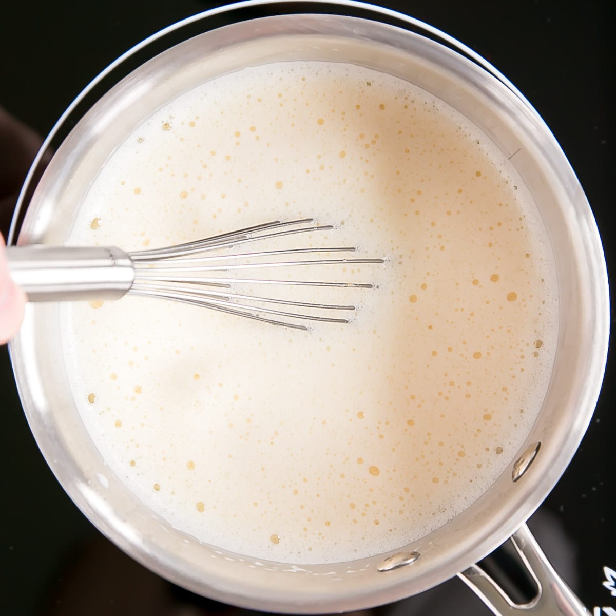 This easy Pastry Cream (Creme Patissiere) recipe is simple and delicious. A rich and creamy vanilla custard you can use in a variety of decadent desserts. | livforcake.com Tempered custard back in the pot on the stove.